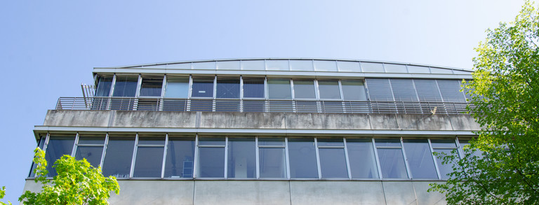 Fassade des Geschossbau 2 mit Bäumen.