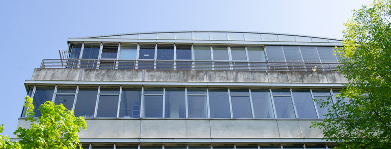 Fassade des Geschossbau 2 mit Bäumen.