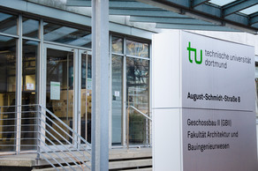 Eingang zum Geschossbau 2, daneben Schild der Fakultät Architektur und Bauingenieurwesen.