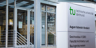 Eingang zum Geschossbau 2, daneben Schild der Fakultät Architektur und Bauingenieurwesen.